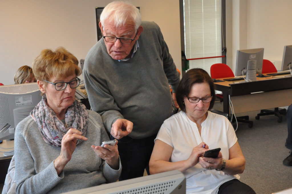 Hans Hogeweg zeigt Senioren, wie ein Smartphone funktioniert. Foto: Stefan Freiwald